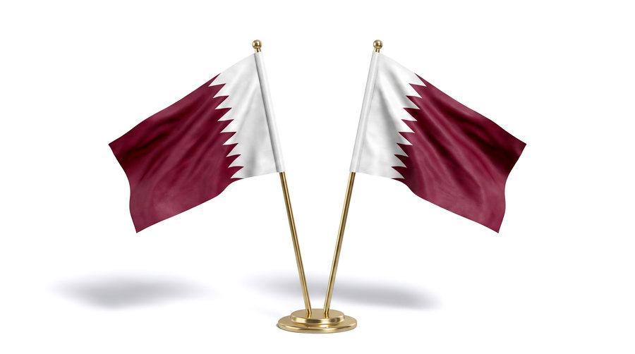 A pair of Qatar desk flags on a polished gilt base.