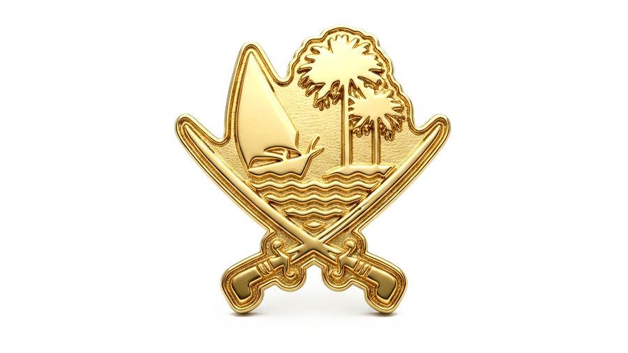 A gold Qatar lapel pin with crossed swords, dhow and palms.