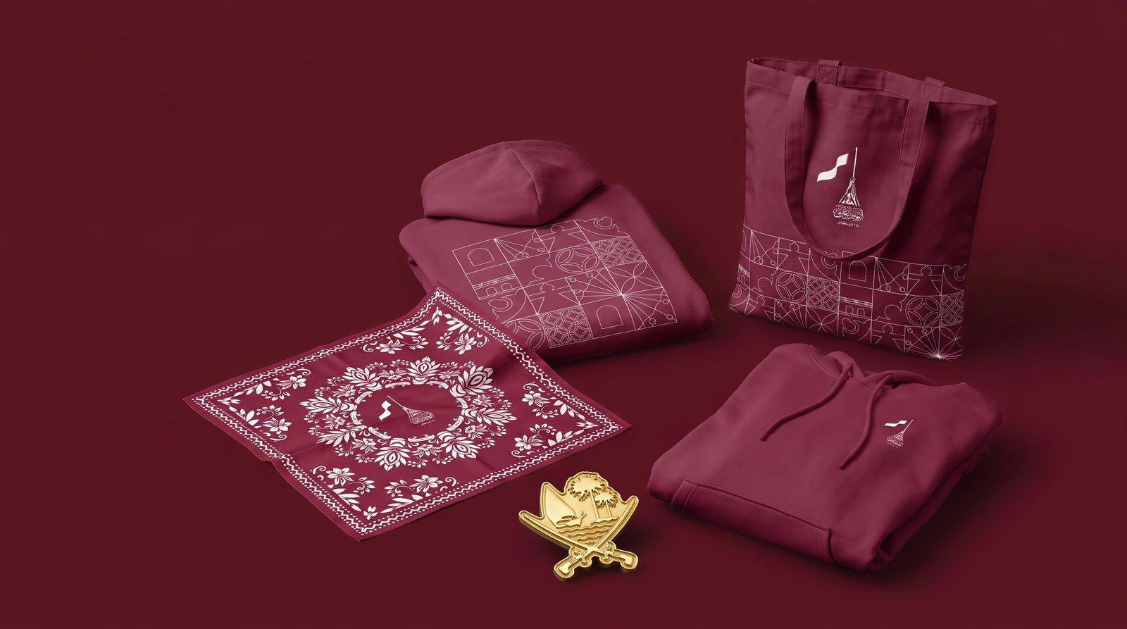 The Izz Qatar set on deep maroon: pattern hoodie, tote bag, floral bandana and gold badge.